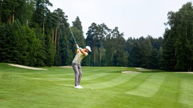 Dışarıda golf oynayan üniformalı genç bir golfçü.