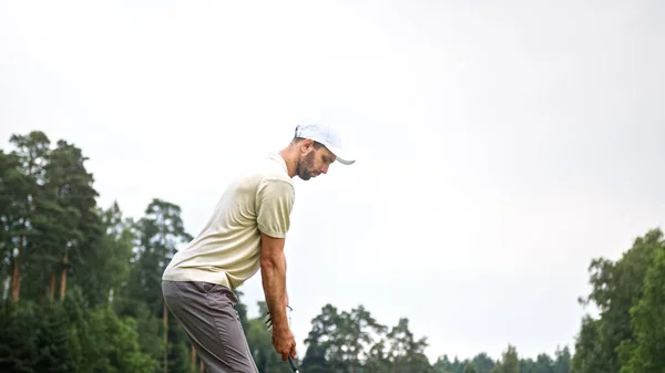 若いスポーツマンが現場でゴルフをしている ロイヤリティフリーのストック画像