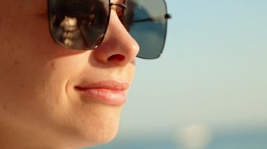 Dışarıda güneş gözlüğü takan genç bir kızın portresi.