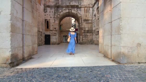 Молода дівчина в синьому платті йде по вулиці в місті. Спліт, Хорватія — стокове відео