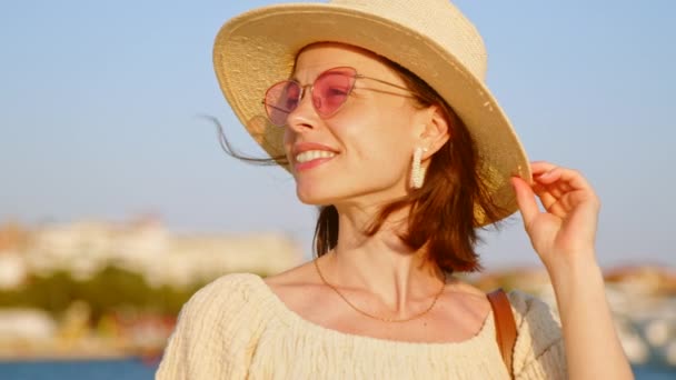 Щаслива дівчина з капелюхом в літньому місті у відпустці, повільне відео руху — стокове відео