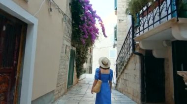 Şehirde şapkalı genç bir kız tatilde, video 6K.