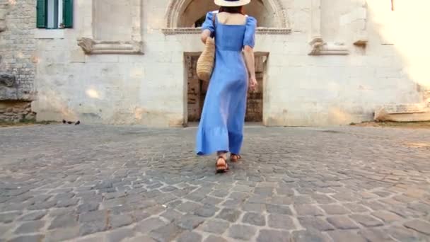 Νεαρή γυναίκα με μπλε φόρεμα που περπατάει στο δρόμο στην πόλη. Σπλιτ, Κροατία — Αρχείο Βίντεο