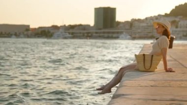 Yazın iskelede çıplak ayaklı çekici bir kadın. Ayrıl, Hırvatistan