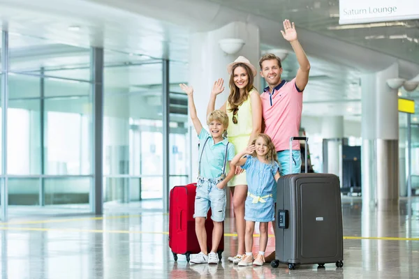 Gelukkige familie met een koffer op de luchthaven — Stockfoto