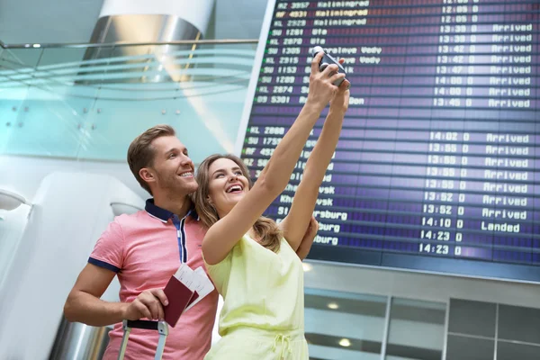 Lachende paar op de luchthaven — Stockfoto