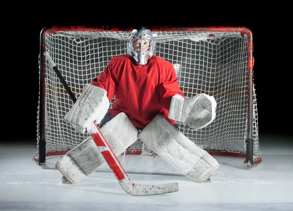 Μια νεαρή-χόκεϊ επί πάγου goaltender σε έτοιμη θέση σε σκούρο — Φωτογραφία Αρχείου