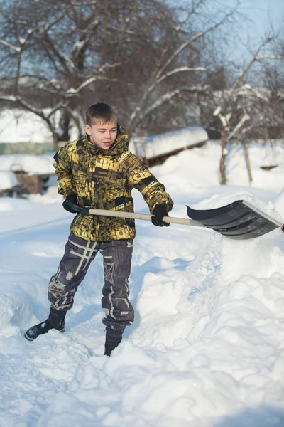 Boy shoveling snow from walkway — Stock Photo, Image