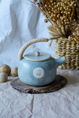 Konforlu bir iç mekanda el yapımı orijinal seramik el yazması. Çaydanlık.