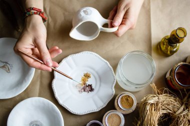 Elle boyama işlemi seramik bir el yapımı tabaklar yaptı. Seçici odak.
