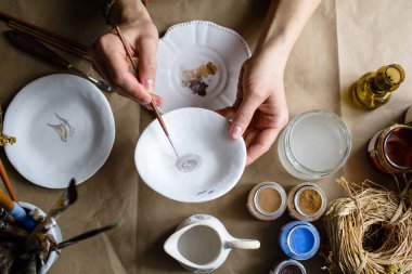 Elle boyama işlemi seramik bir el yapımı tabaklar yaptı. Seçici odak.