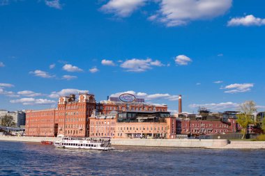 MOSCOW, RUSSIA - 1 Mayıs 2021: Balchug Adası 'ndaki Krasny Oktyabr fabrikası manzaralı Moskova Nehri üzerinde seyrüsefer