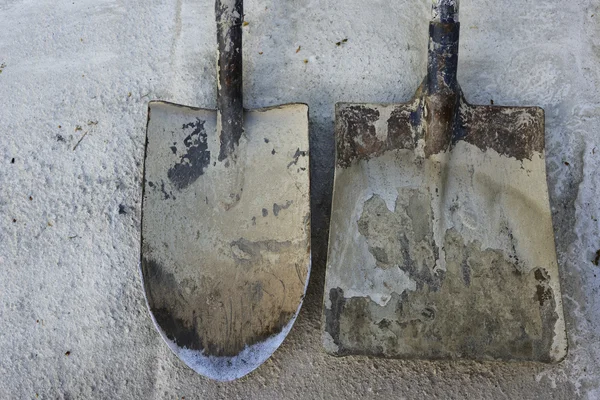 Twee vuile spade op de betonnen ondergrond — Stockfoto