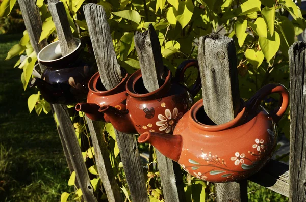 Four ceramic teapot on a fence — Stock Photo, Image