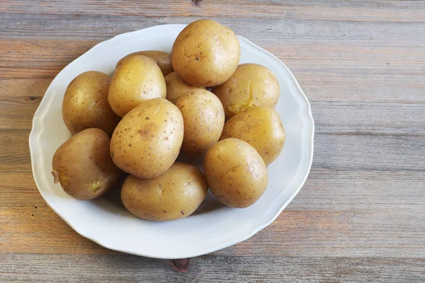 Gekookte aardappelen in hun huid op een plaat — Stockfoto