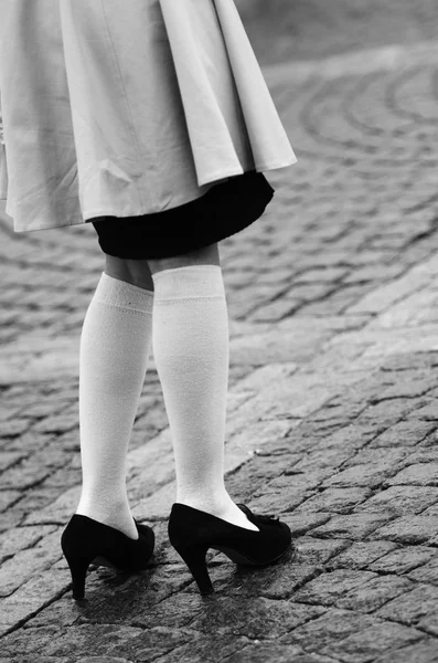 Gambe femminili in calzini e scarpe nere Foto Stock