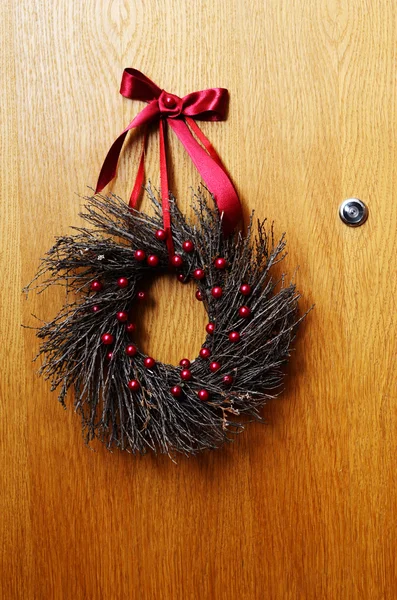 Porta de madeira com uma grinalda de Natal — Fotografia de Stock