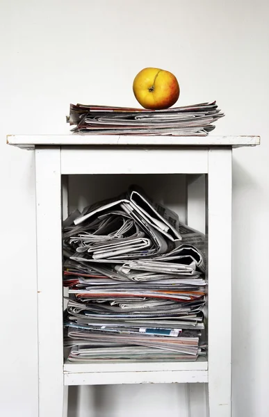 Bunt med tidningar på nattduksbordet och ett äpple — Stockfoto