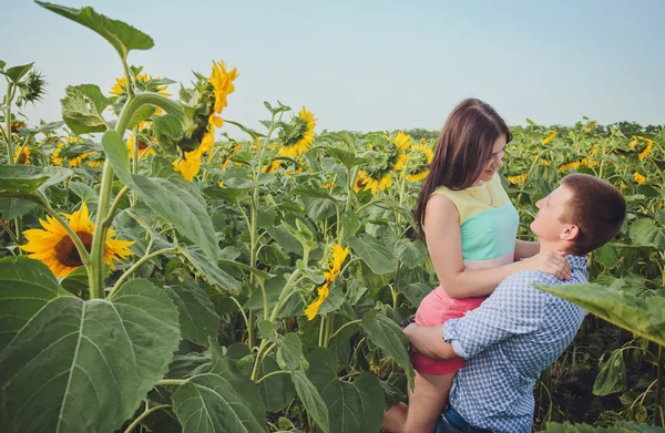 Paar in einem Feld von Sonnenblumen — Stockfoto