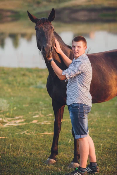 Joven abraza a un caballo — Foto de Stock