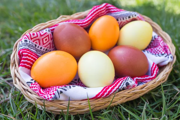 Unique hand painted Easter eggs in basket on grass. — Stock Photo, Image