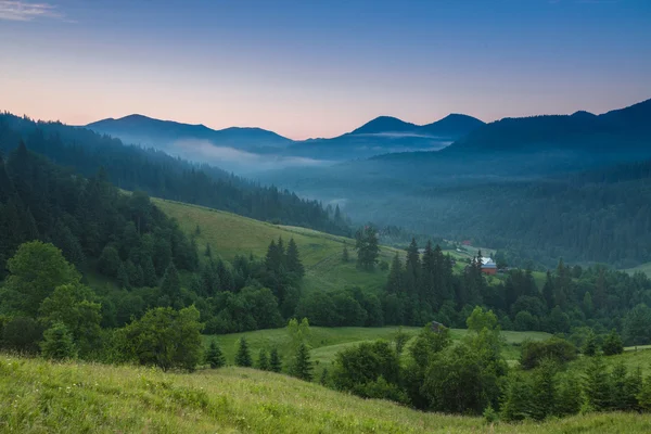 Летний пейзаж с деревней в горах — стоковое фото