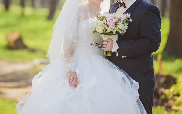 Elegante bruid en bruidegom poseren samen buitenshuis — Stockfoto