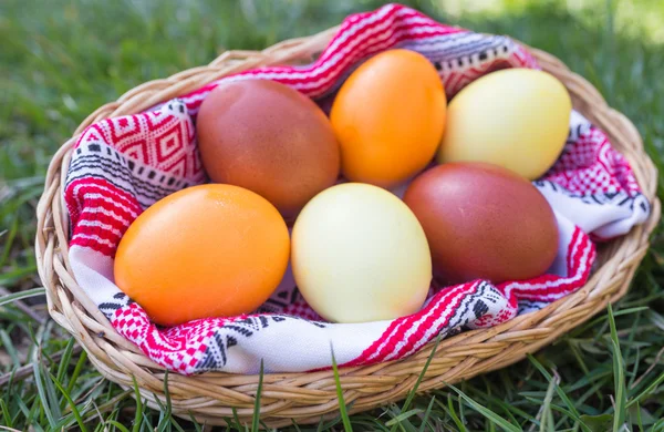 Unique hand painted Easter eggs in basket on grass. — Stock Photo, Image