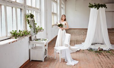 Pencere kenarında gelinlik içinde güzel bir gelin portresi.