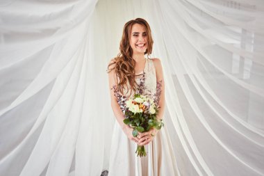 Güzel, yumuşak bir düğün buketi. Kremalı güller ve gelinin ellerinde östoma çiçekleri.