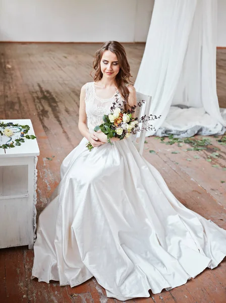 Uma Noiva Bonita Vestido Branco Está Sentado Uma Cadeira Perto — Fotografia de Stock