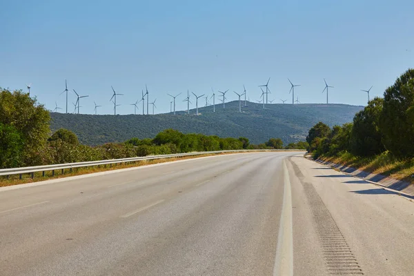 Rüzgar Türbini Yeşil Sarı Alanda Önde Boş Bir Yol Arkasında — Stok fotoğraf