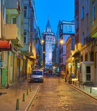 İSTANBUL, TURKEY - 23 Nisan: Şehir binaları tarafından çerçevelenmiş Galata Kulesi 'nin muhteşem gece manzarası - İstanbul.