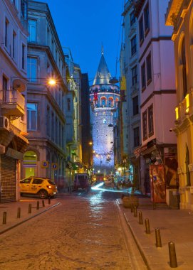 İSTANBUL, TURKEY - 23 Nisan: Şehir binaları tarafından çerçevelenmiş Galata Kulesi 'nin muhteşem gece manzarası - İstanbul.