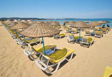 CESME -TURKEY - 25 Nisan 2018: Açık deniz kıyısındaki Ilica plajında boş güneşlikler, Cesme, Türkiye