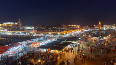 MARRAKESH, FOCCO - 2 Şubat 2017: Kimliği belirsiz insanlar gün batımında Jemaa el Fna Meydanı 'nı ziyaret ederler. Meydan UNESCO Dünya Mirası 'nın bir parçası.