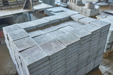 Paving levha fabrikası. Paletlerin içinde fayanslar yığılmış. Fabrikada üretim için kaldırım döşemeleri var.