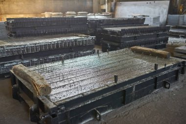 Beton levhalar üretiyorum. güçlendirilmiş beton üretimi. Metalle çalışan işçiler, beton takviyesi için kaynak yapıyorlar. Ev inşa fabrikası. Endüstriyel iç mekan. Beton fabrikası.