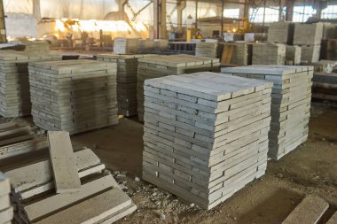 Paving levha fabrikası. Paletlerin içinde fayanslar yığılmış. Fabrikada üretim için kaldırım döşemeleri var.