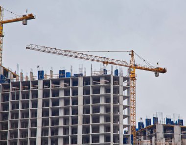 Gökyüzü arka planında vinçleri olan inşaat alanı