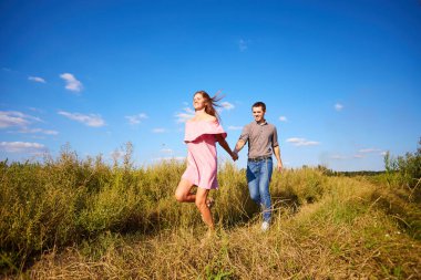 Genç bir çifti el ele tutuşurken ve parkta koşarken çekmişler. Bulanık hareket, yumuşak odaklanma