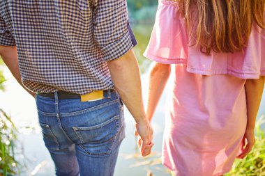 Nehir kenarında durup gün batımını izleyen birbirine aşık bir çiftin bulanık arkaplanı. Renk filtreli fotoğraf.