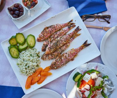 Akdeniz restoranı. Ekmeğin yanında kızarmış balık ve sebze tabağı.
