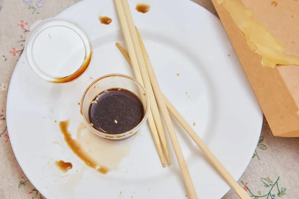 Witte Plaat Met Houten Eetstokjes Met Resterende Saus Sushi — Stockfoto