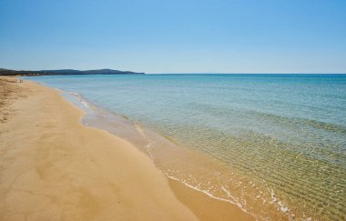 Güzel güneşli kıyı manzarası kristal berrak su ve kumlu kumsal boş bir yerde Yunanistan 'ın Kos, Dodecanese Adaları, Yunanistan' ın bazı dağları ile çevrili