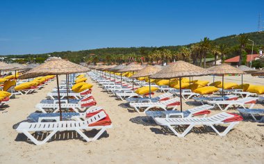 Boş güneşlik ve güneş şemsiyeleri sabah, deniz kenarında. Deniz kıyısındaki lüks oteldeki kumsal. Güzel bir sabah deniz manzarası. Bodrum, Türkiye