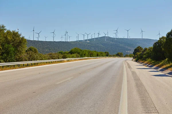 Rüzgar Türbini Yeşil Sarı Alanda Önde Boş Bir Yol Arkasında — Stok fotoğraf