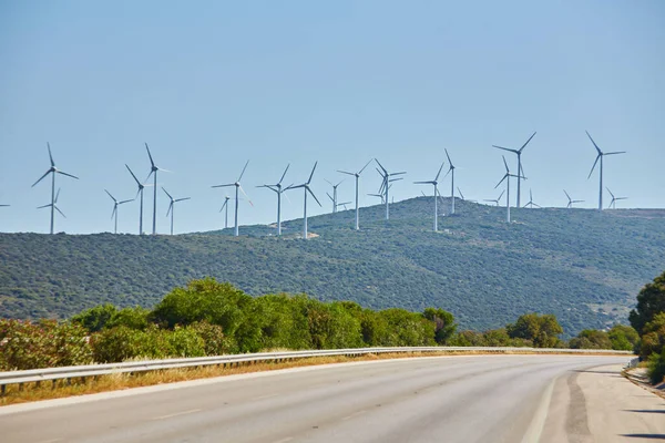 Uzakta Rüzgar Türbinleri Olan Tepelerden Geçen Bir Yol — Stok fotoğraf