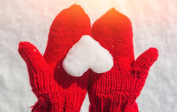 snowflake in the form of heart on red mittens