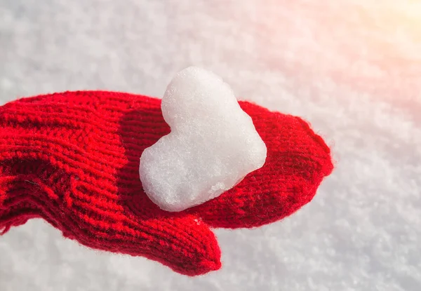 Kalp şeklinde kar taneleri kırmızı eldivenler üzerinde